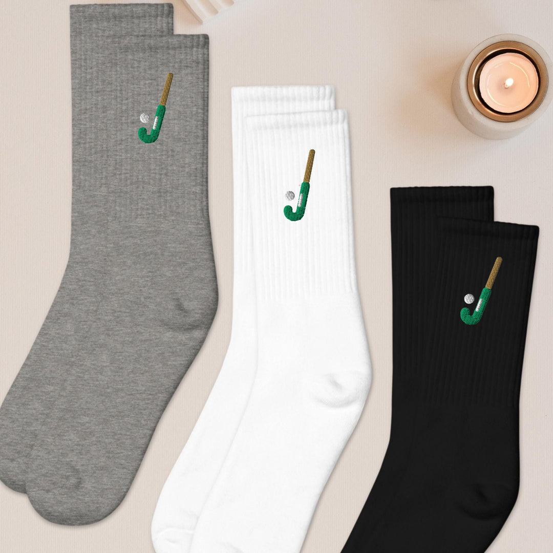 three pairs of socks sitting next to a candle