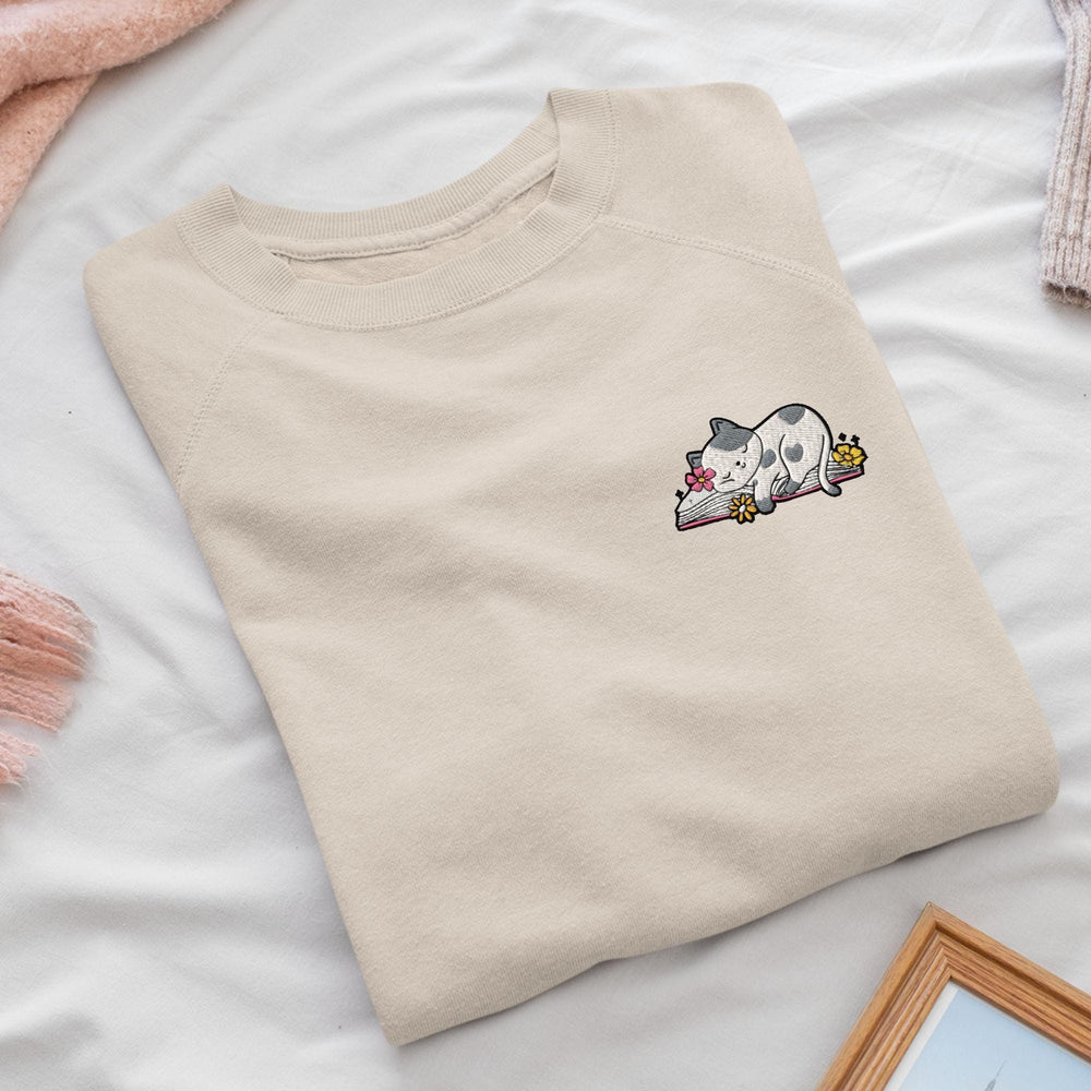 a white t - shirt with a cartoon cat laying on top of it