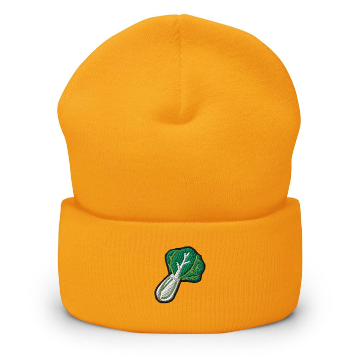 a yellow beanie with a green leaf on it
