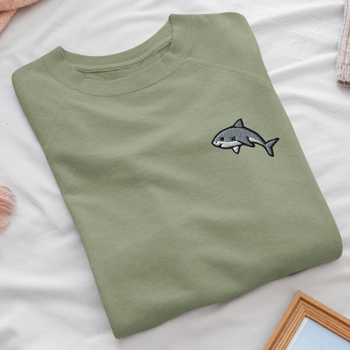 a green t - shirt with a shark embroidered on it