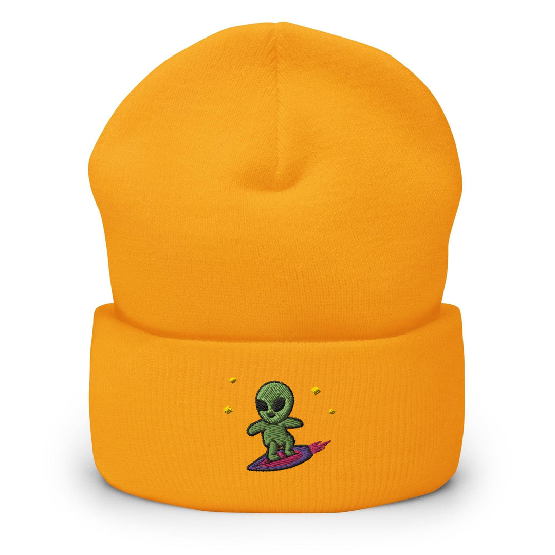 a yellow beanie with a green alien on it