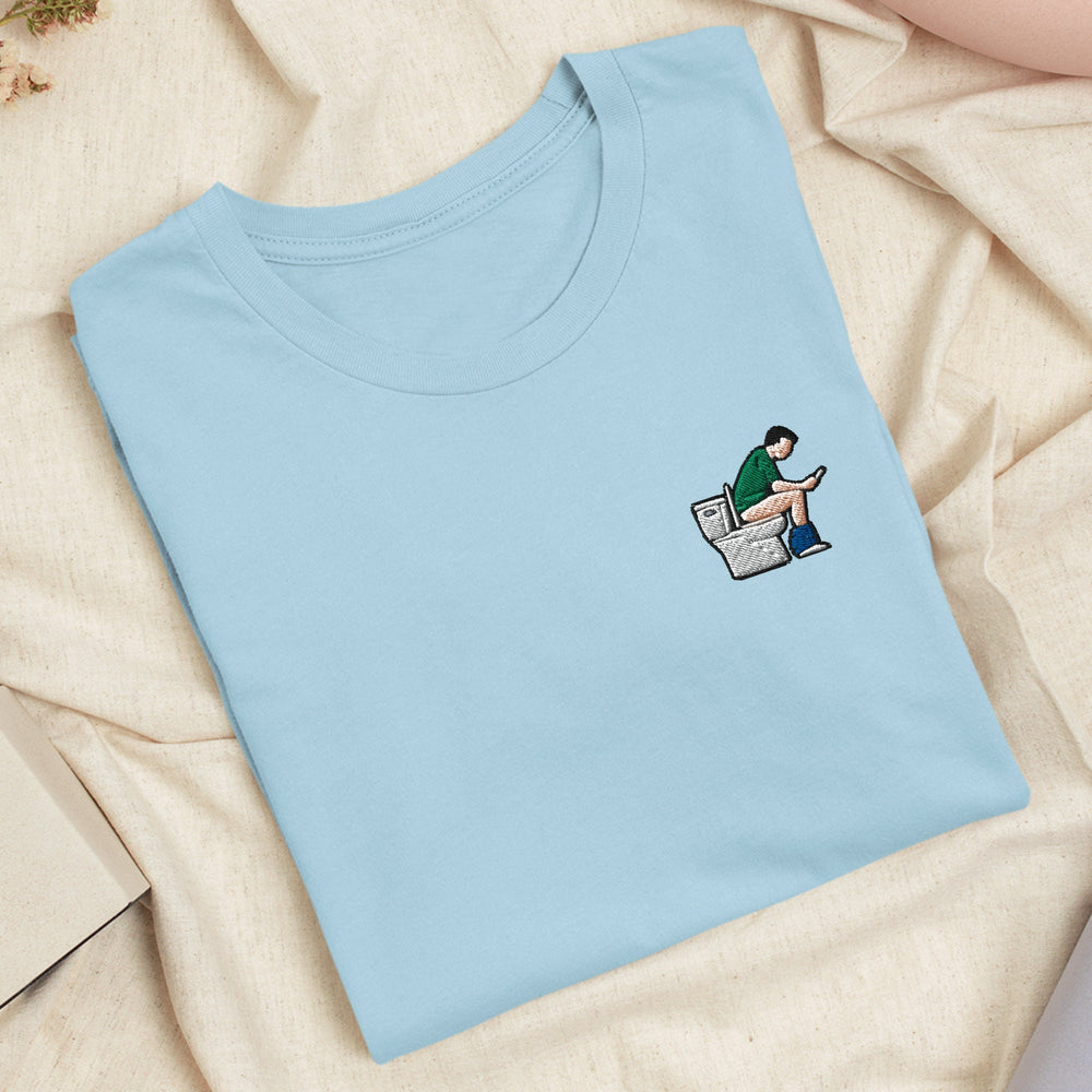 a blue t - shirt with a picture of a man sitting on a newspaper