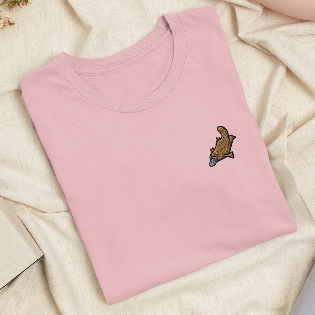 a pink t - shirt with a brown bear embroidered on it