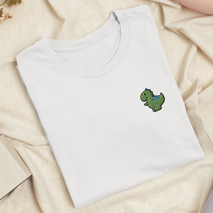 a white t - shirt with a green dinosaur embroidered on it