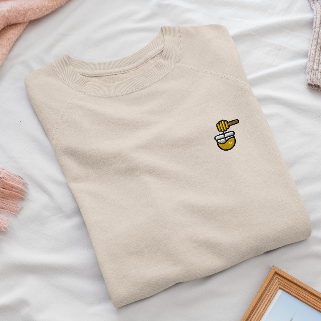 a white t - shirt with a bee embroidered on it