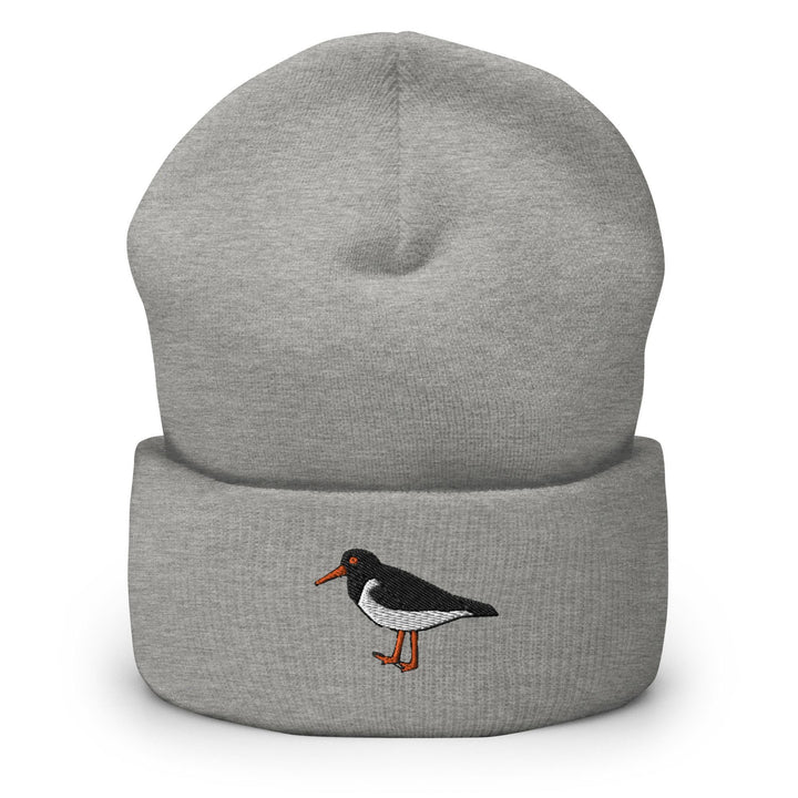 a grey beanie with a black and white bird on it