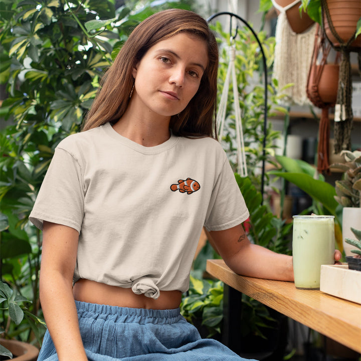 a woman sitting at a table in a greenhouse