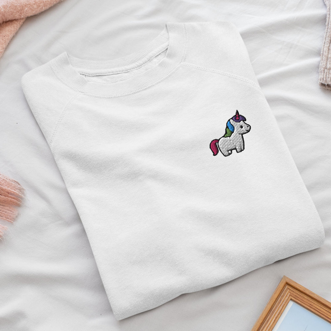 a white t - shirt with a unicorn embroidered on it