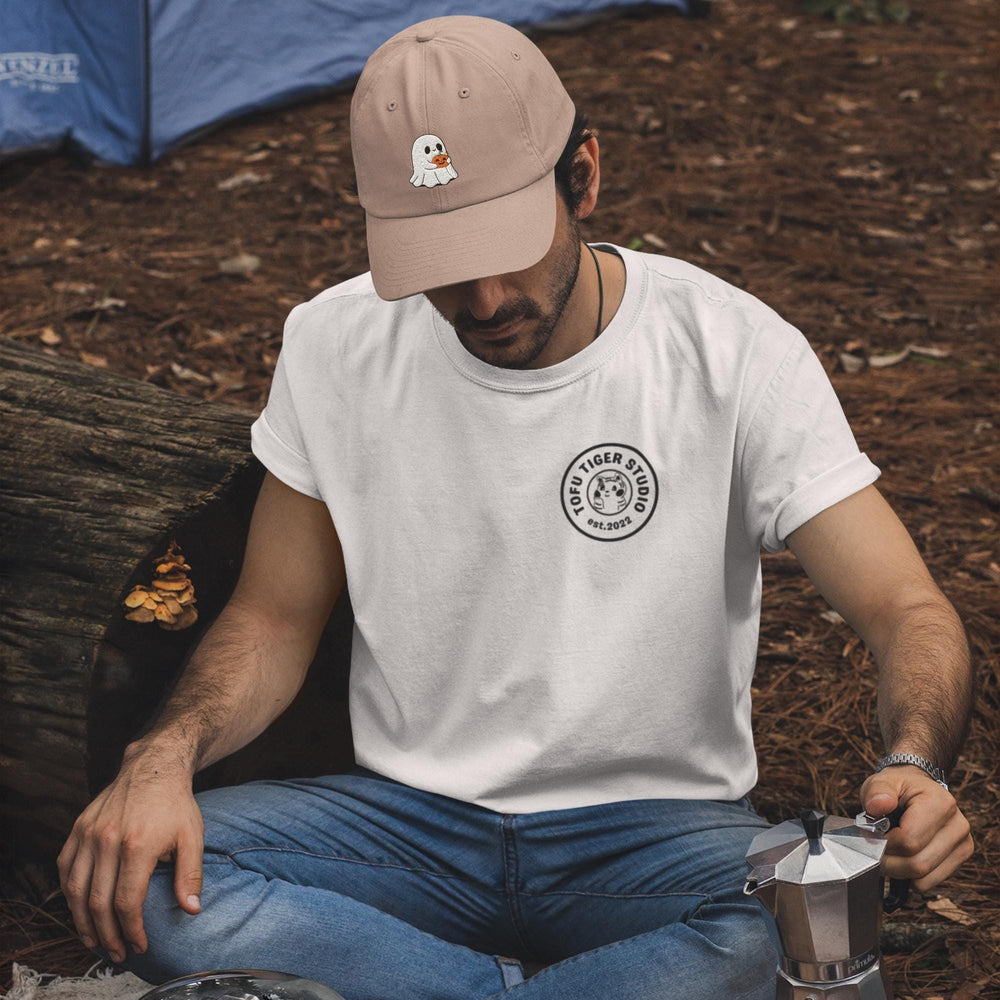 a man sitting on the ground next to a tree