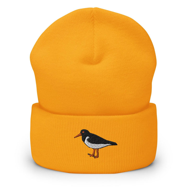 a yellow hat with a black and white bird on it