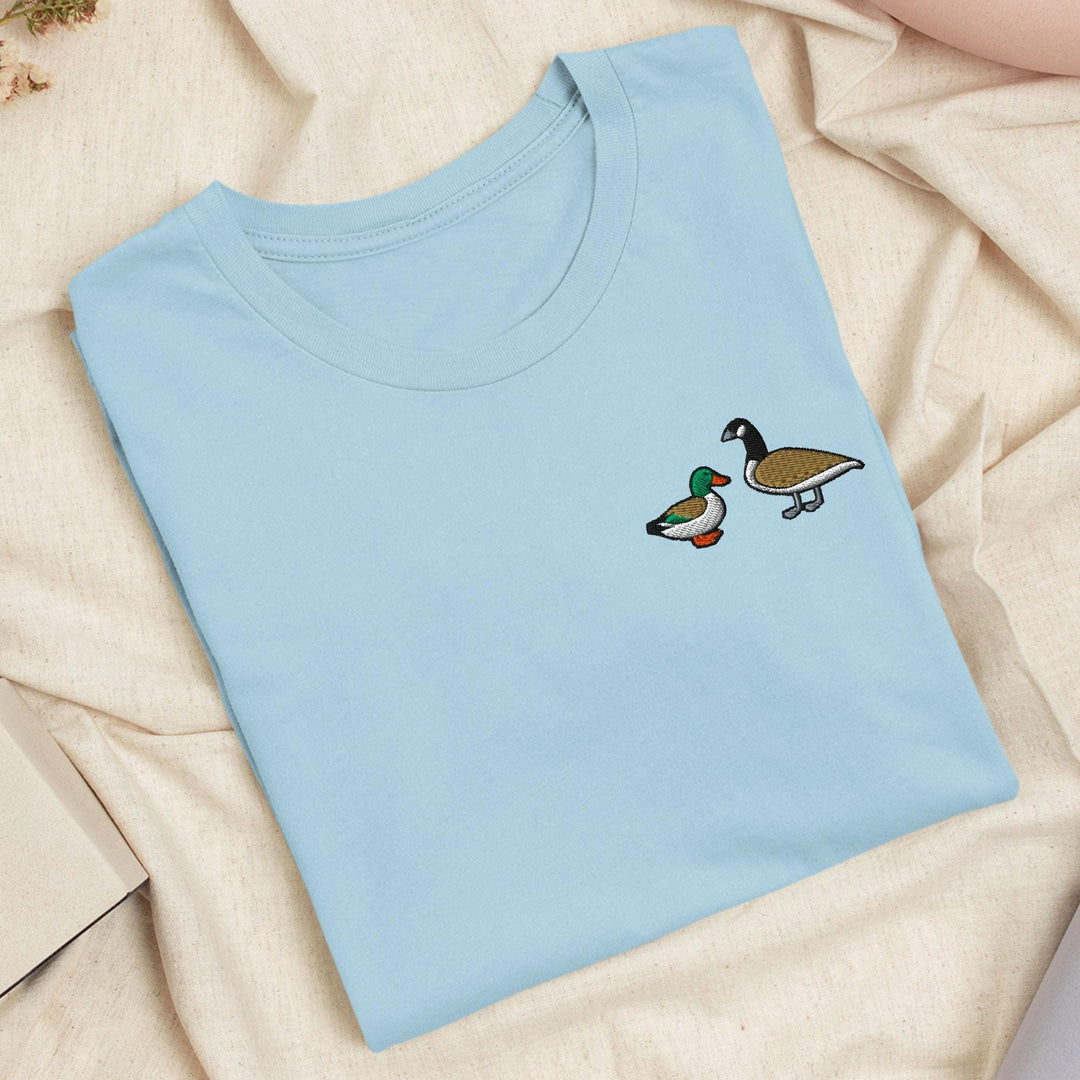 a blue t - shirt with two ducks on it