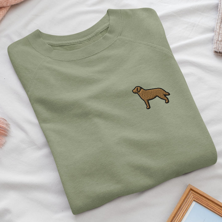 a green t - shirt with a brown dog embroidered on it