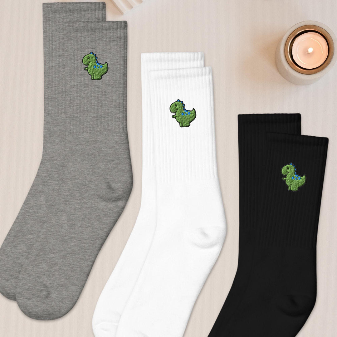 three pairs of socks sitting next to a candle