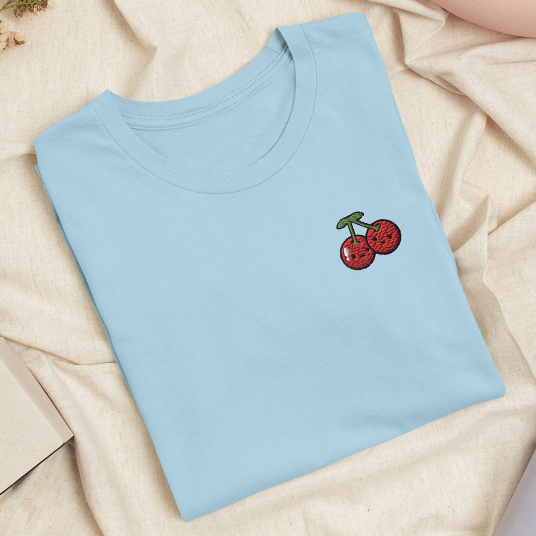 a blue t - shirt with a cherry embroidered on it