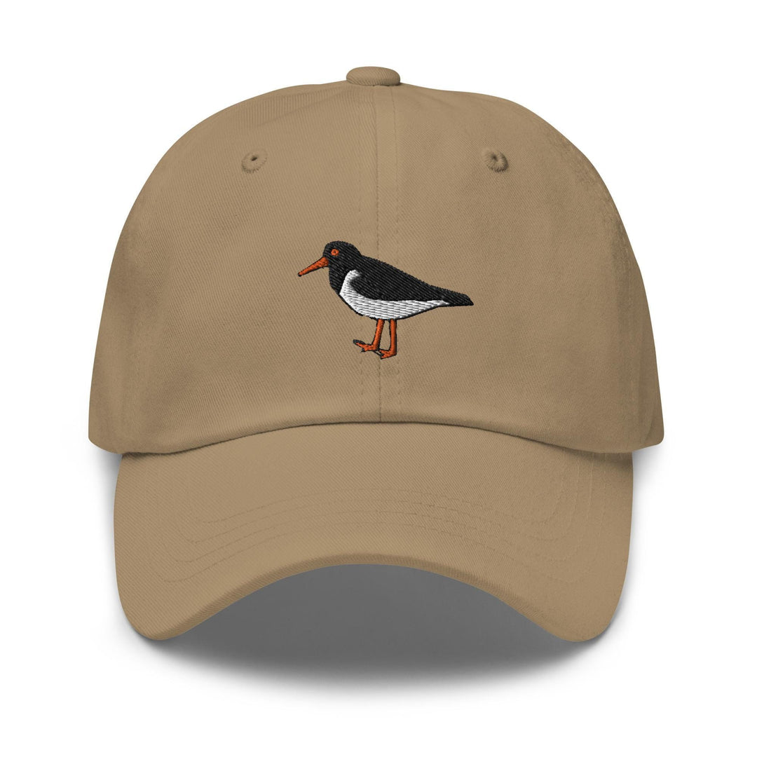 a tan hat with a black and white bird embroidered on it