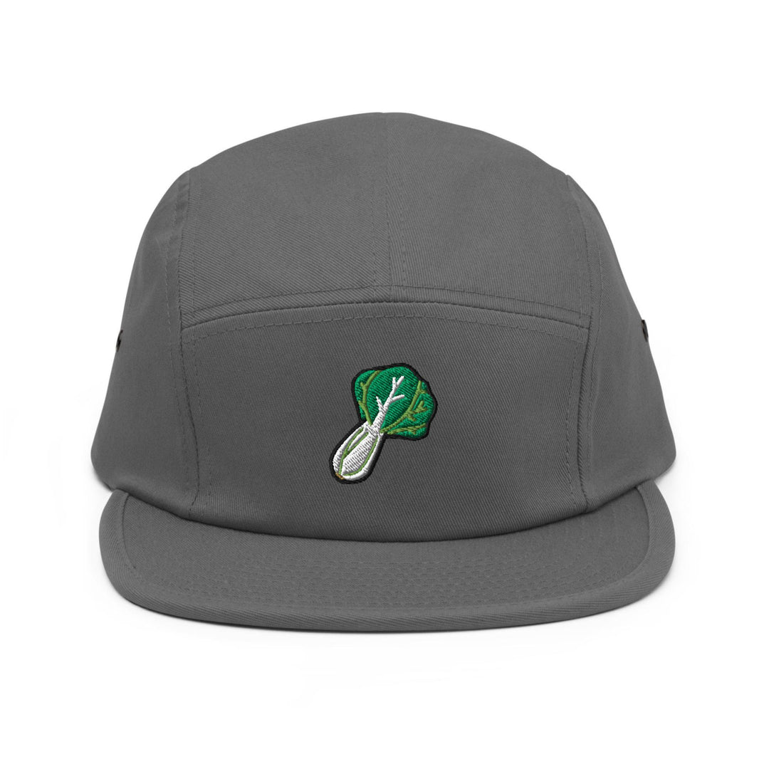 a gray hat with a green leaf on it