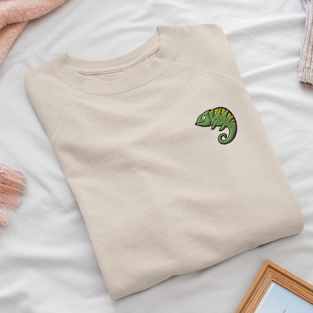 a t - shirt with a green chamelon embroidered on it