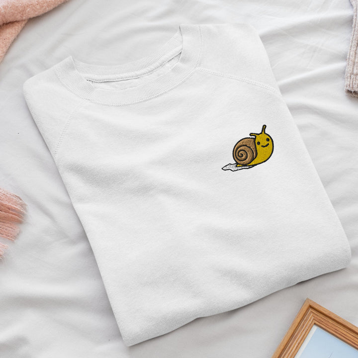 a white t - shirt with a snail embroidered on it