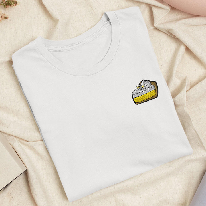 a white t - shirt with a piece of cake on it
