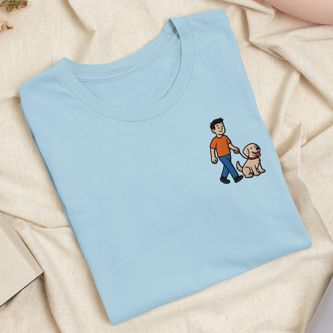 a blue t - shirt with a picture of a man walking a dog