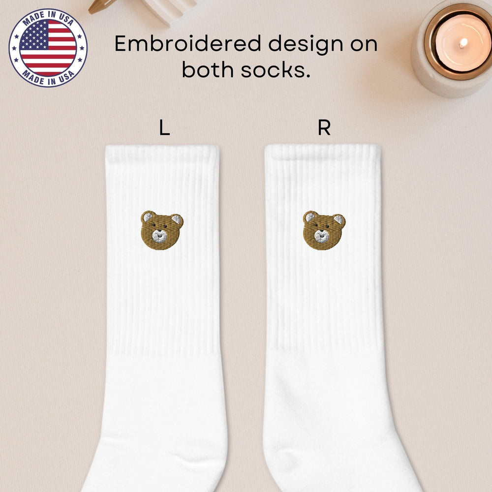 a pair of white socks with a brown bear on it