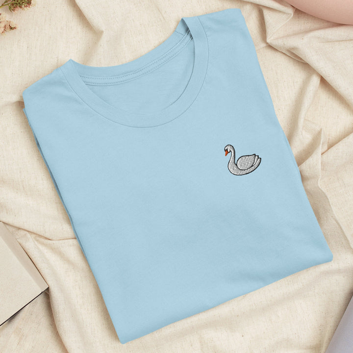 a blue t - shirt with a white swan embroidered on it