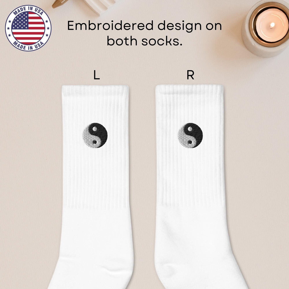 a pair of white socks with a yin symbol on them