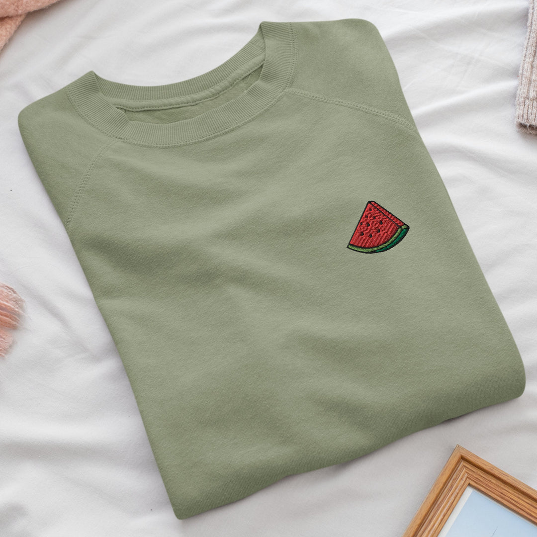 a watermelon t - shirt on a bed next to a mirror