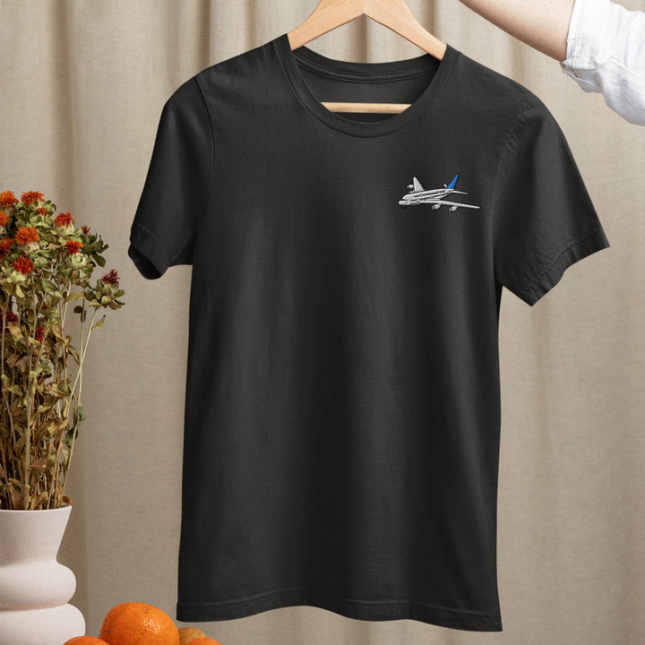a black t - shirt with a plane embroidered on it