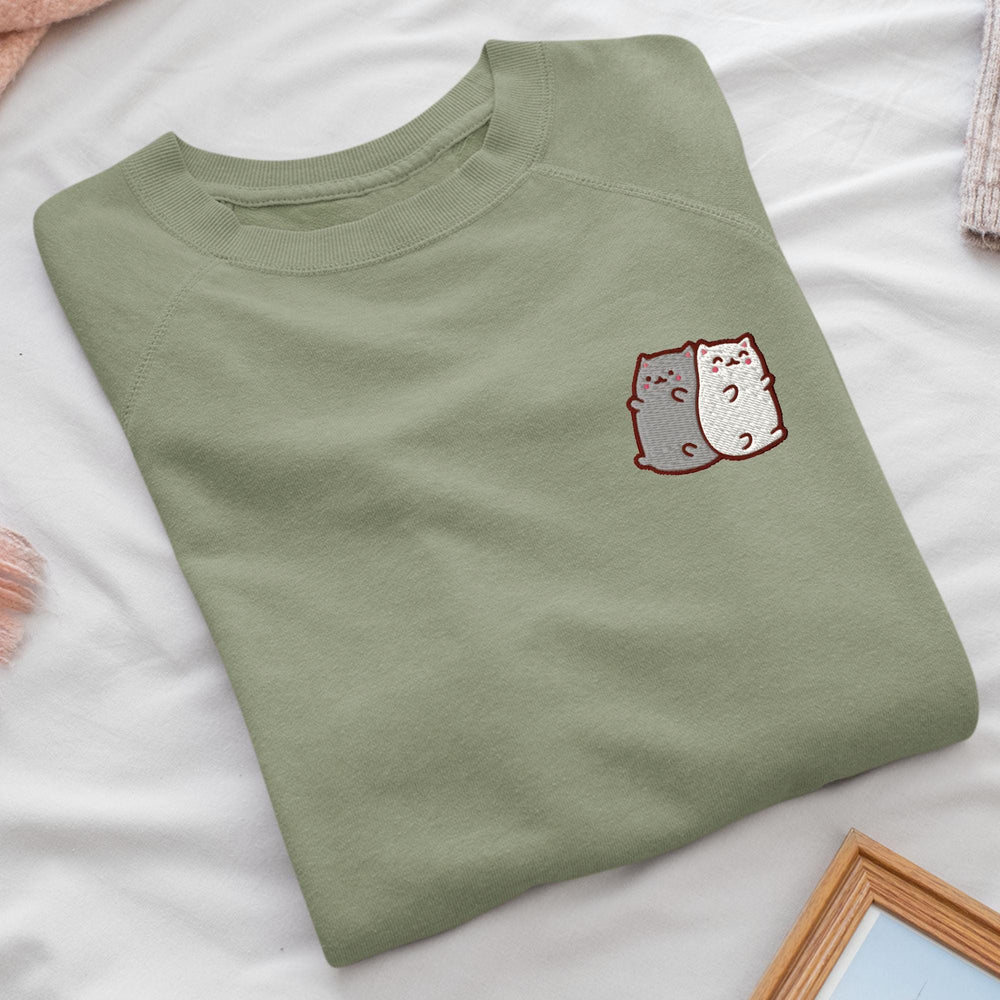 a green t - shirt with a picture of two cats on it