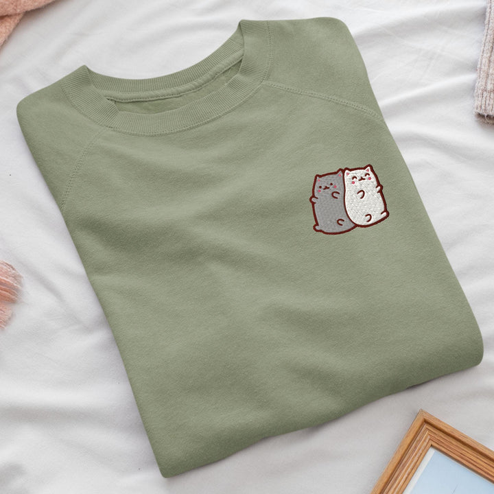 a green t - shirt with a picture of two cats on it