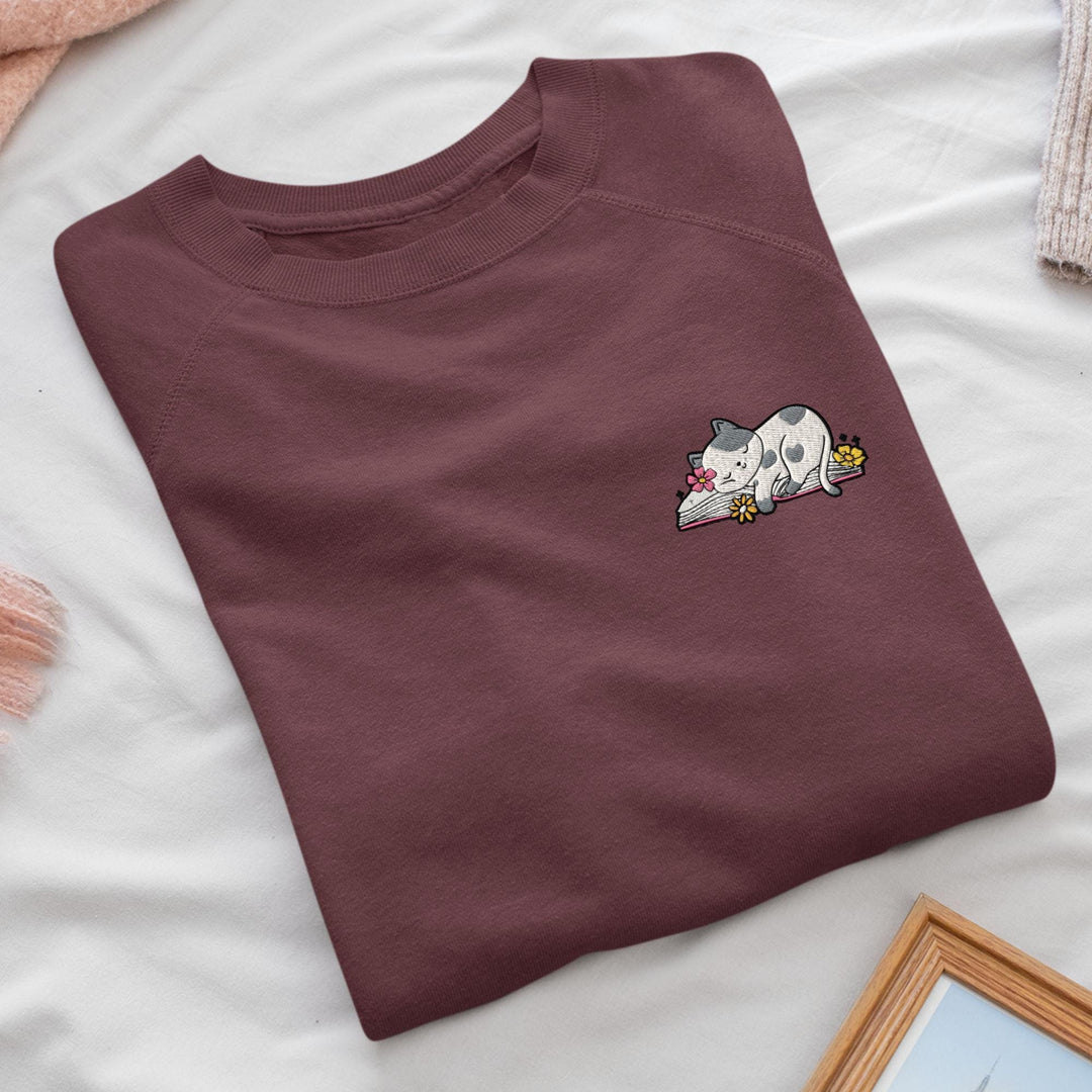 a t - shirt with a picture of a cat laying on top of it