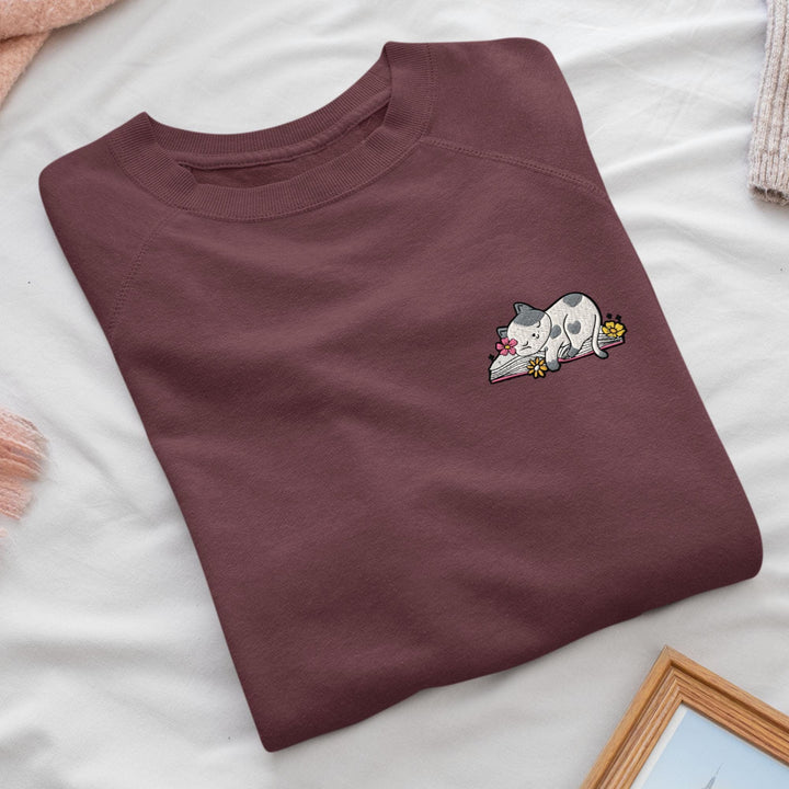 a t - shirt with a picture of a cat laying on top of it