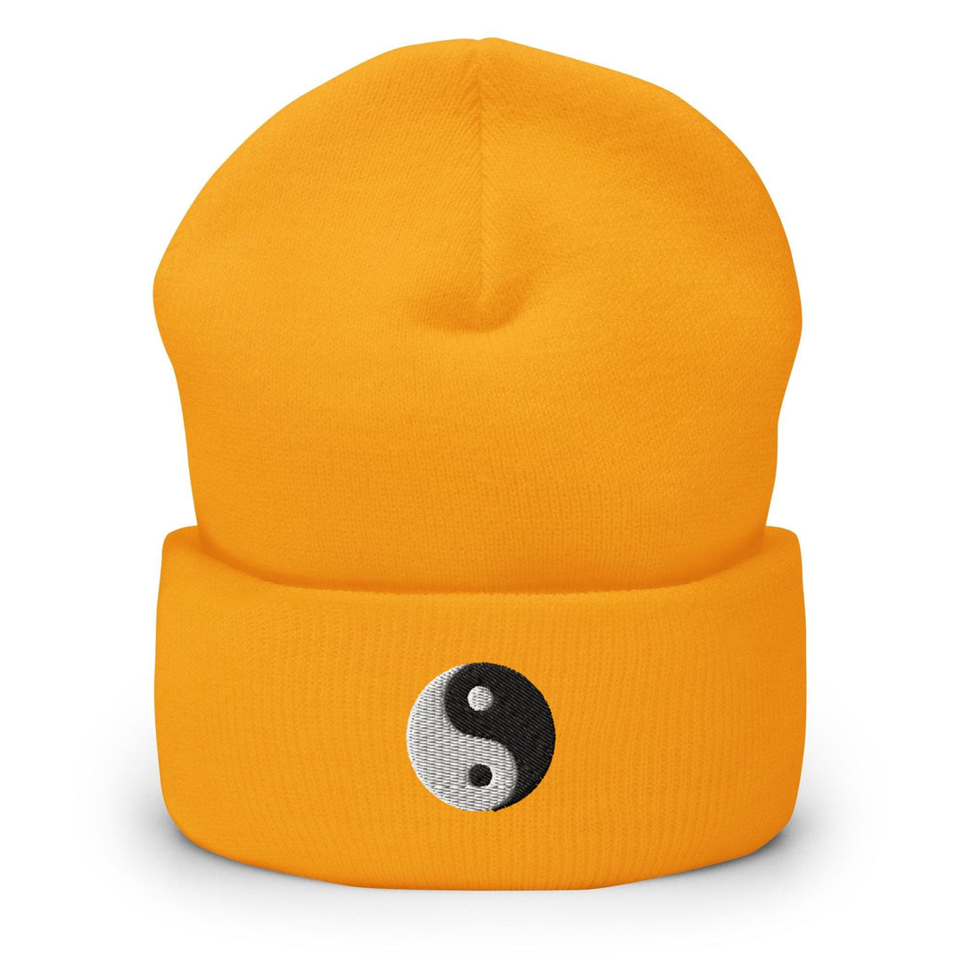 a yellow beanie with a yin symbol on it