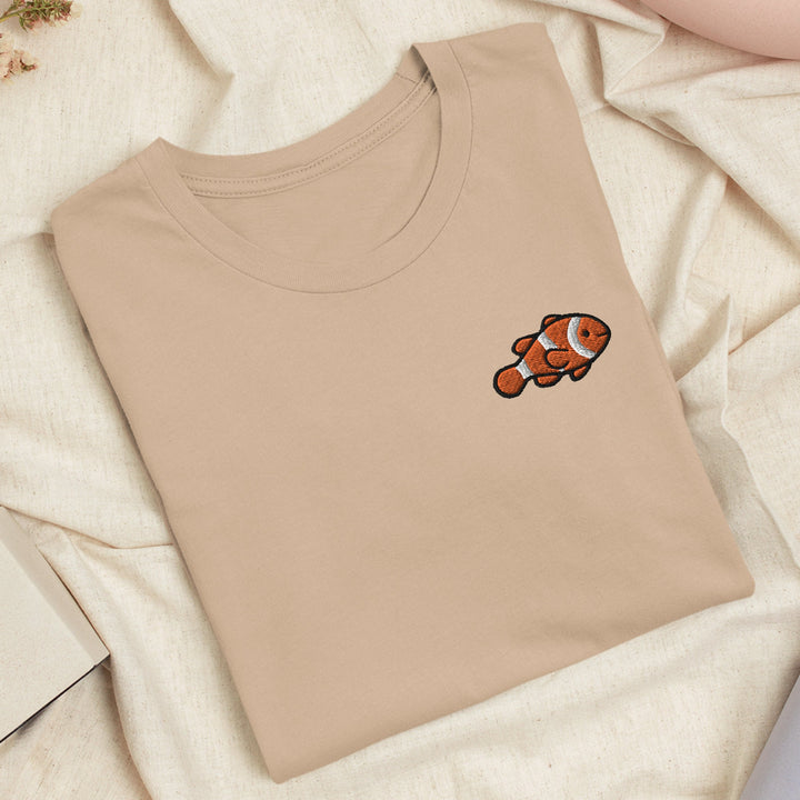 a t - shirt with an orange fish embroidered on it