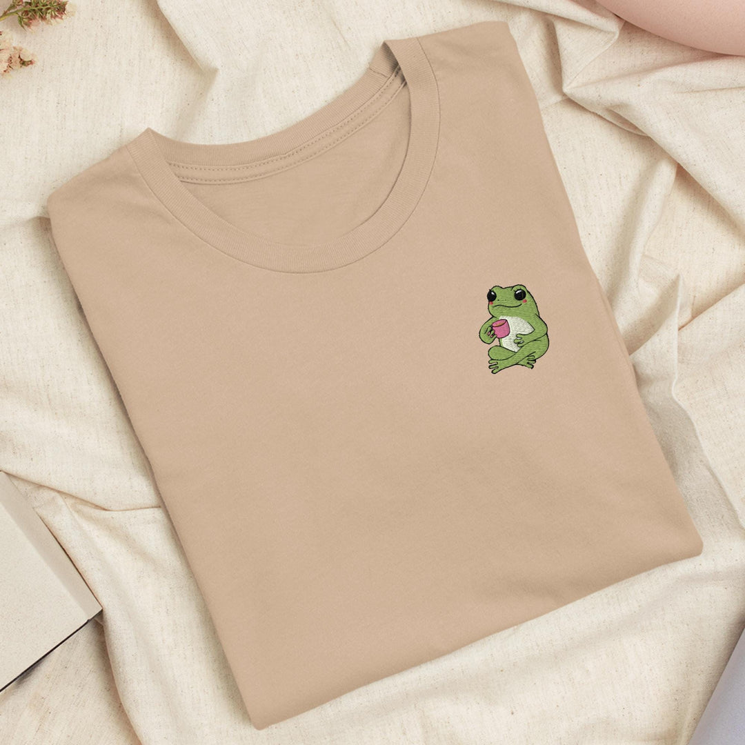 a t - shirt with a frog holding a heart on it