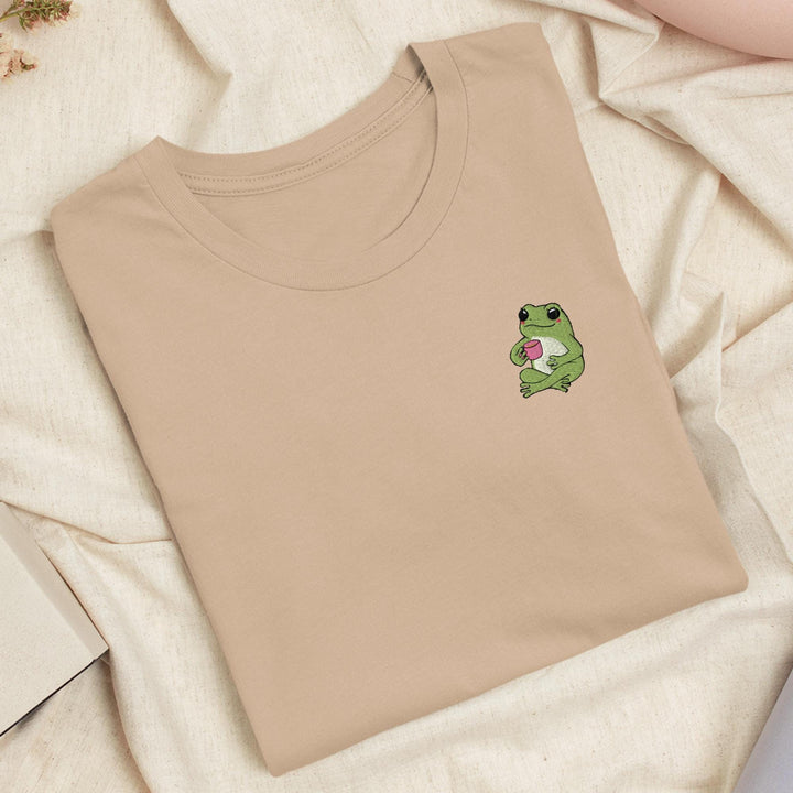 a t - shirt with a frog holding a heart on it