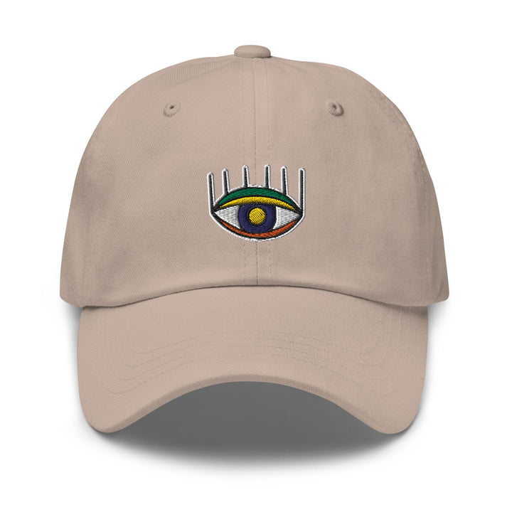a tan hat with an eye and a comb on it