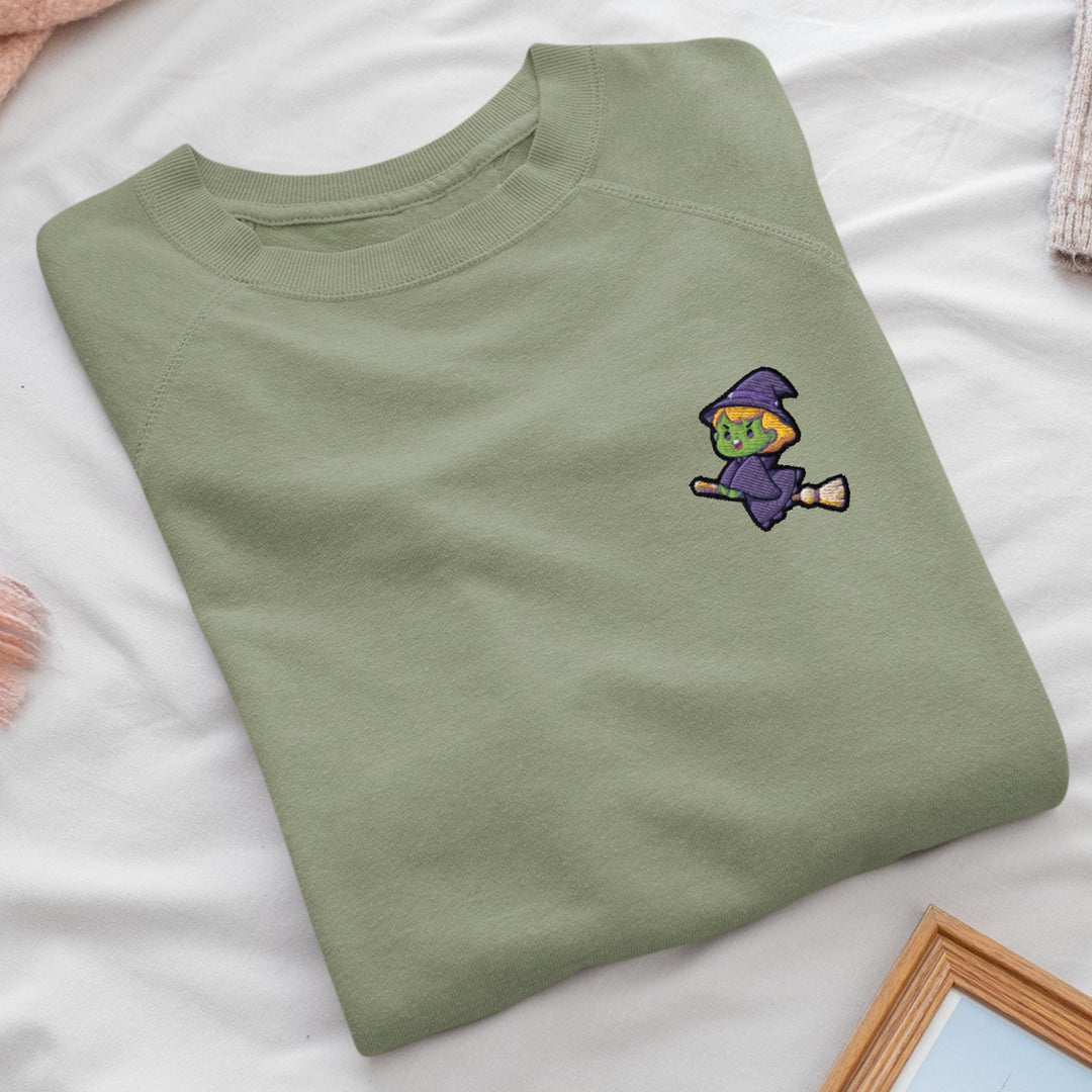 a green t - shirt with a picture of a witch on it