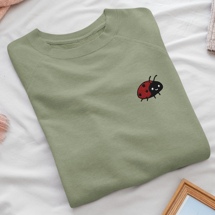 a green shirt with a ladybug embroidered on it
