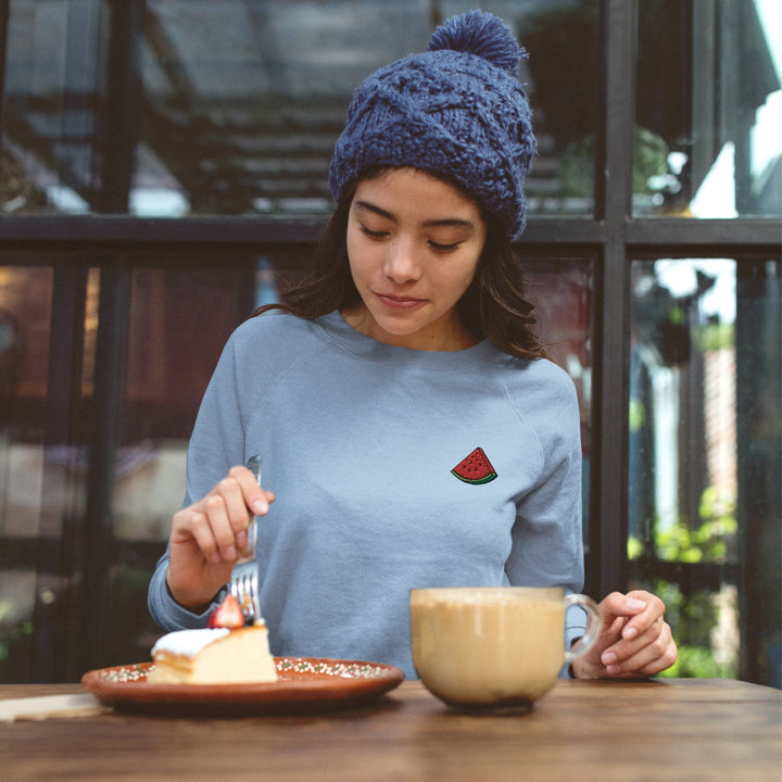 a woman sitting at a table eating cake