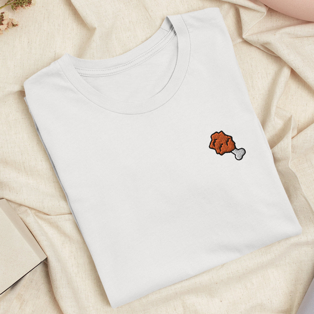a white t - shirt with a red fish embroidered on it