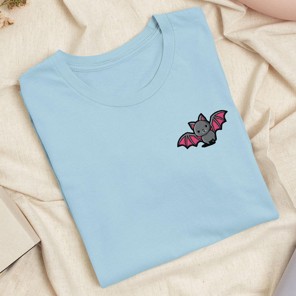 a blue t - shirt with a bat embroidered on it