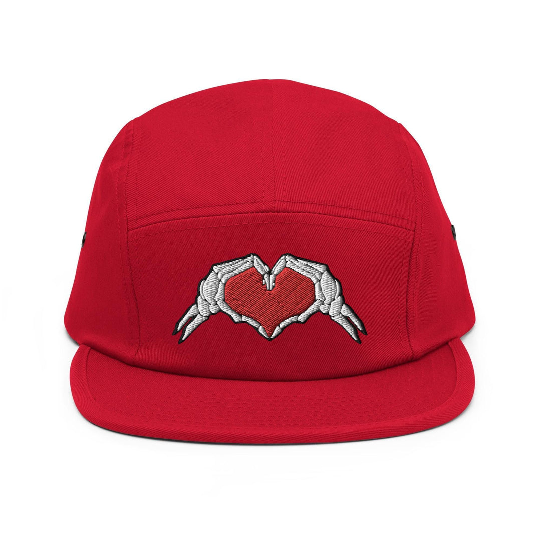 a red hat with two hands holding a heart