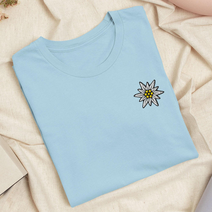 a blue t - shirt with a flower embroidered on it