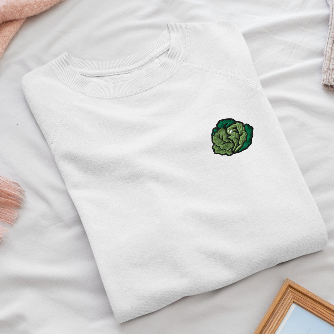a white t - shirt with a green head on it