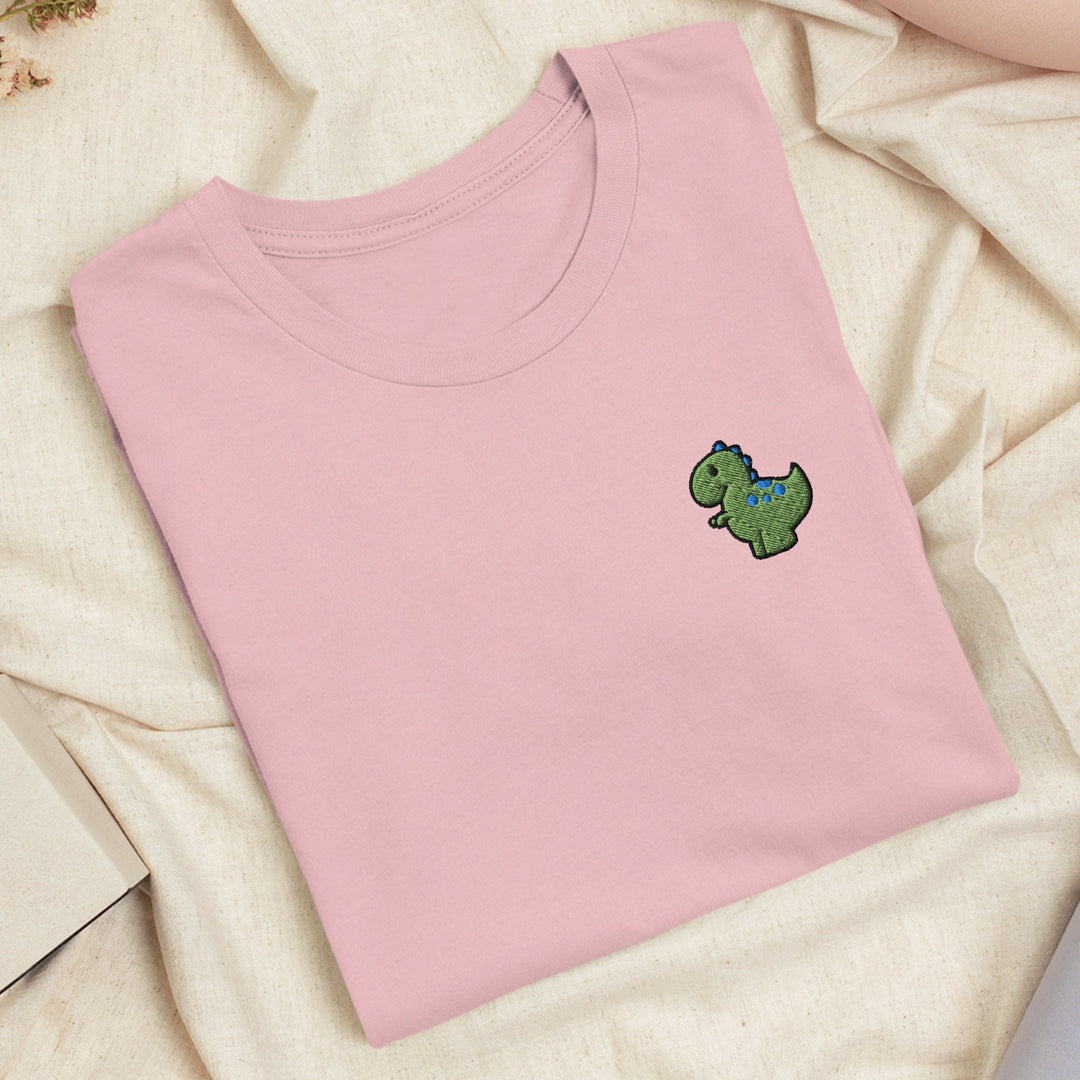 a pink shirt with a green dinosaur embroidered on it