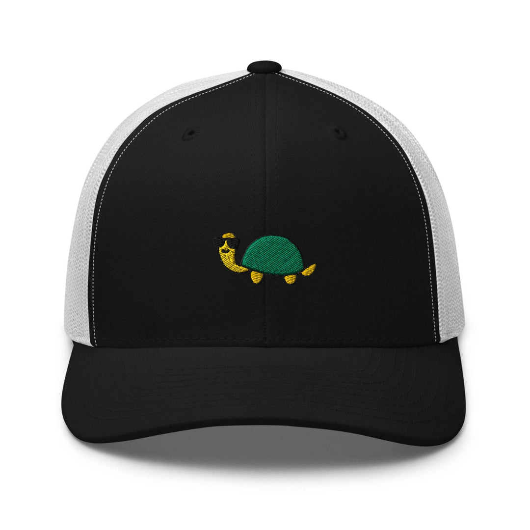 a black and white hat with a green turtle on it
