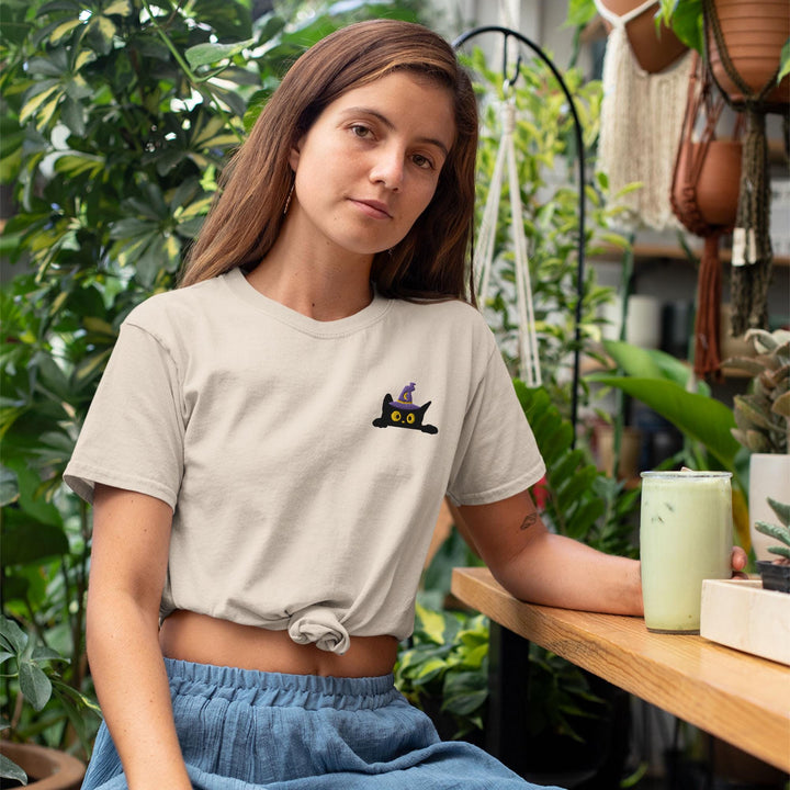 a woman sitting at a table with a plant in the background