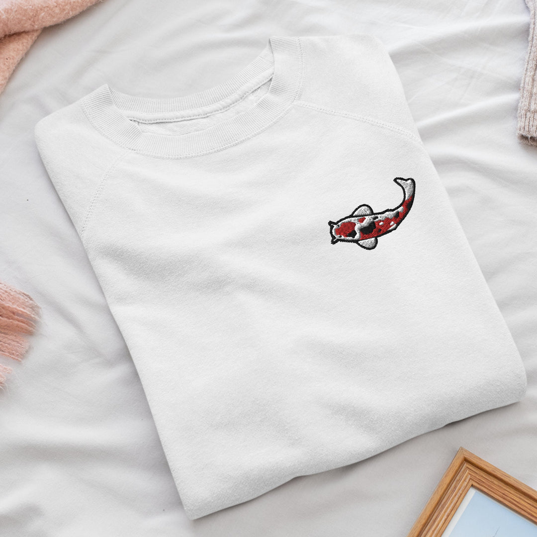 a white t - shirt with a fish embroidered on it